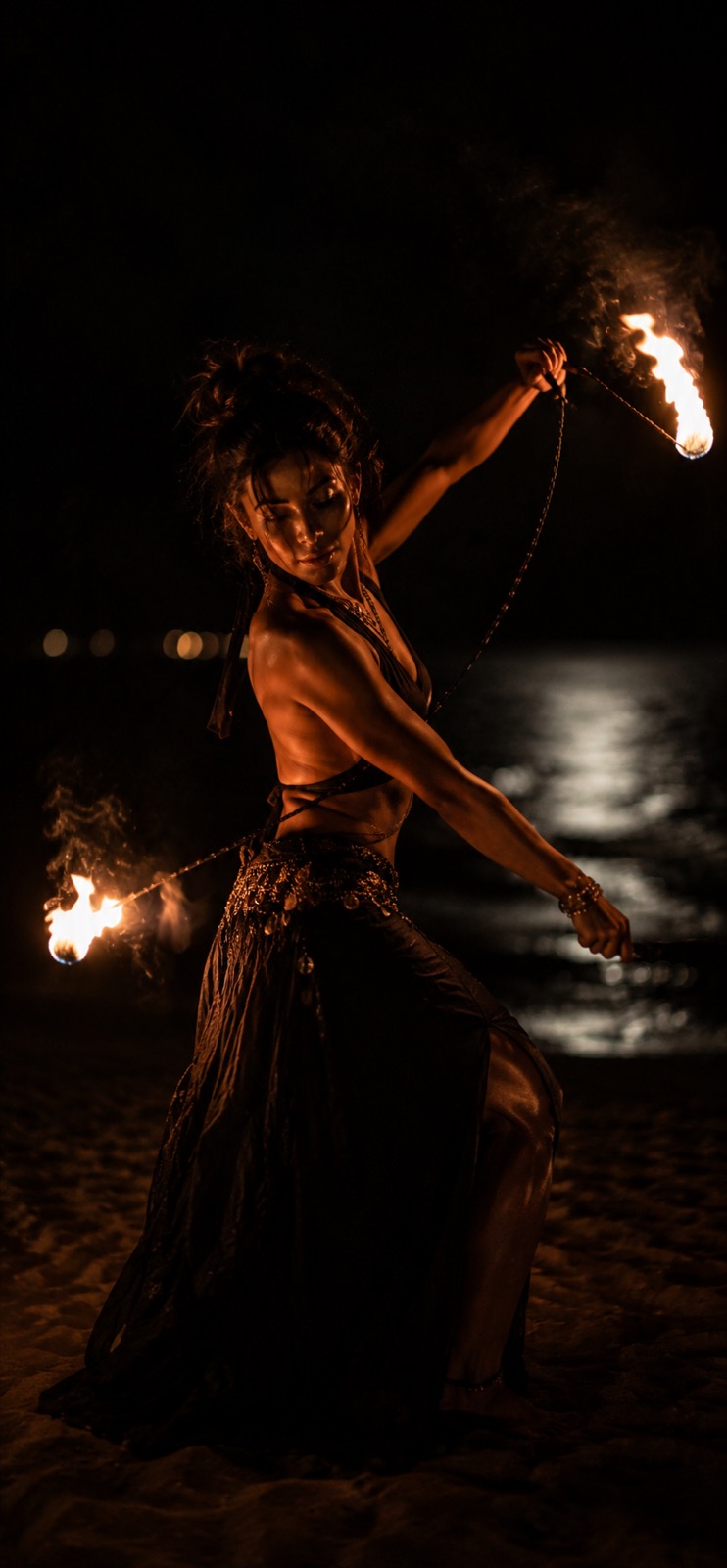 Fire performer dancing on the beach at night