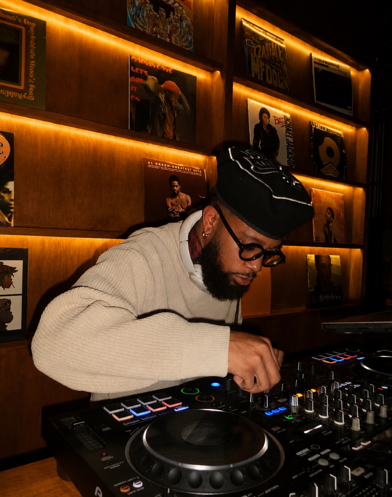 DJ performing behind a record wall